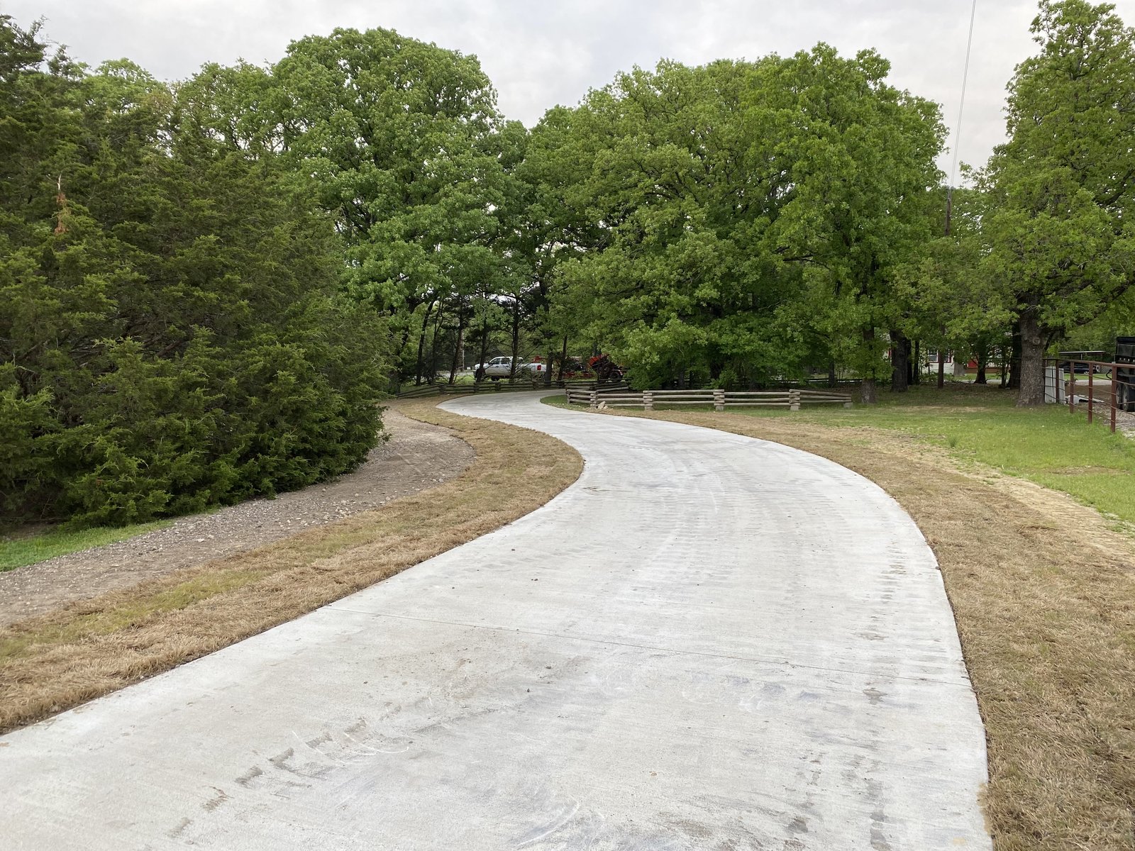 S-curve driveway with finish grading and sod installation along the edges