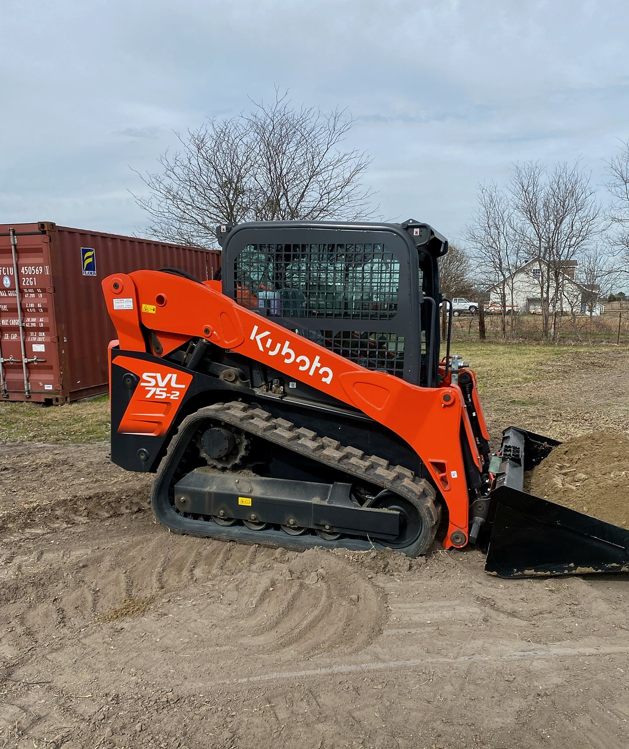 Orange Kubota SVL 75-2 compact track loader on a dirt site