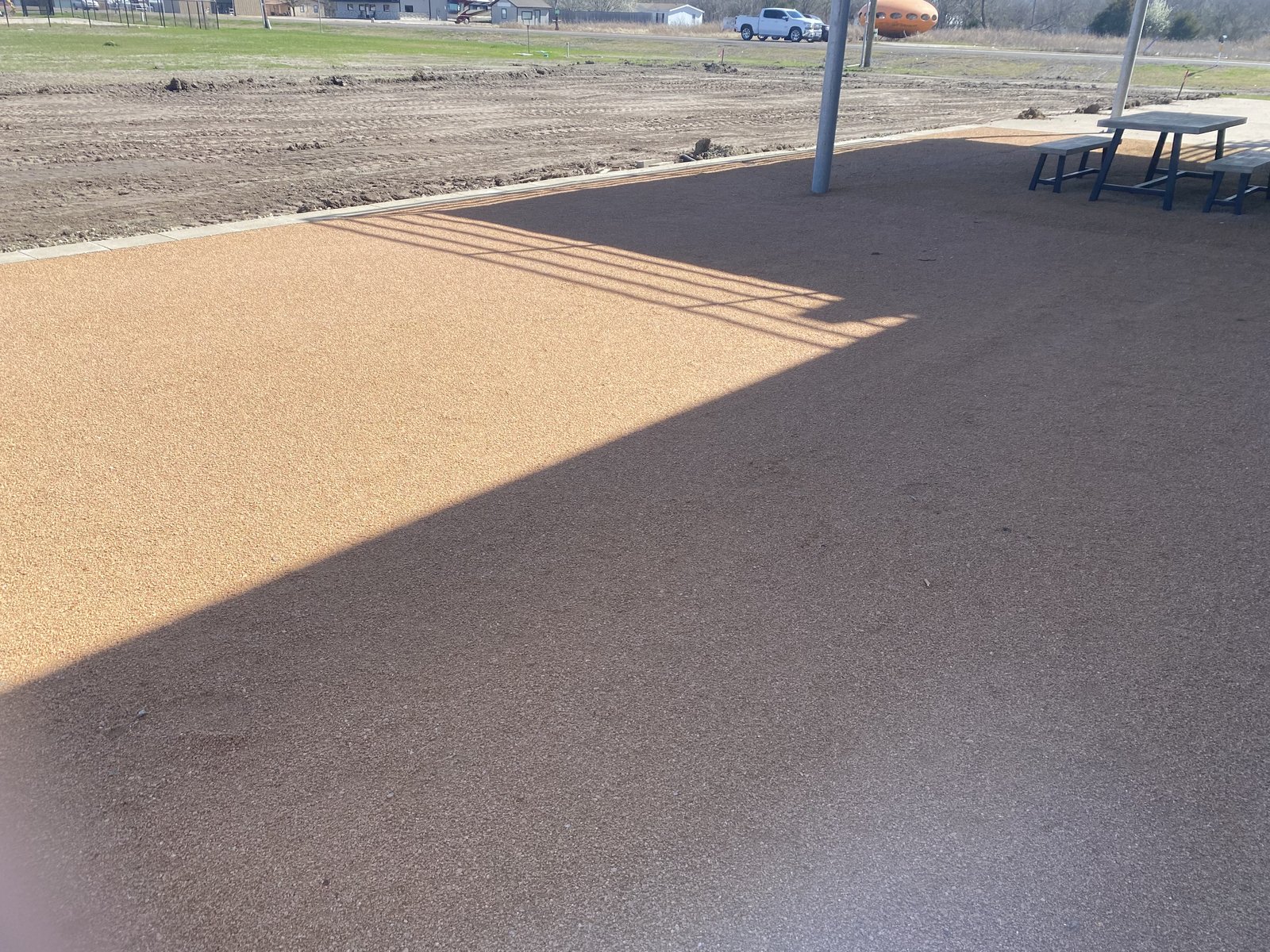 Compacted gravel patio with picnic table beside graded dirt