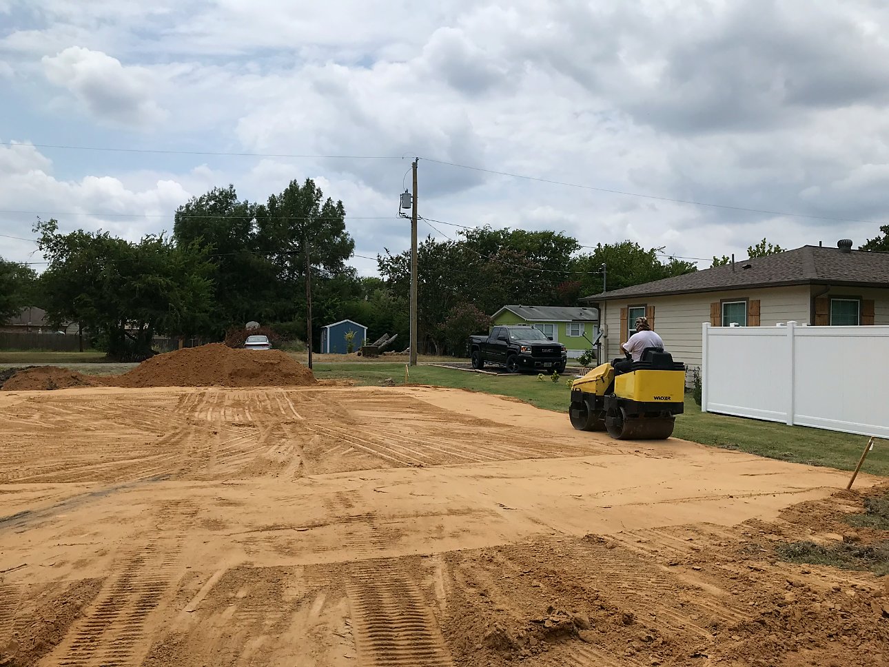 Yellow roller compacting sand on a pad
